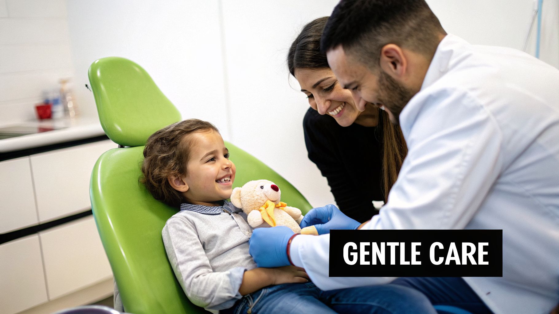 A smiling child with a teddy bear in a dental chair, with a dentist and a woman providing gentle care.