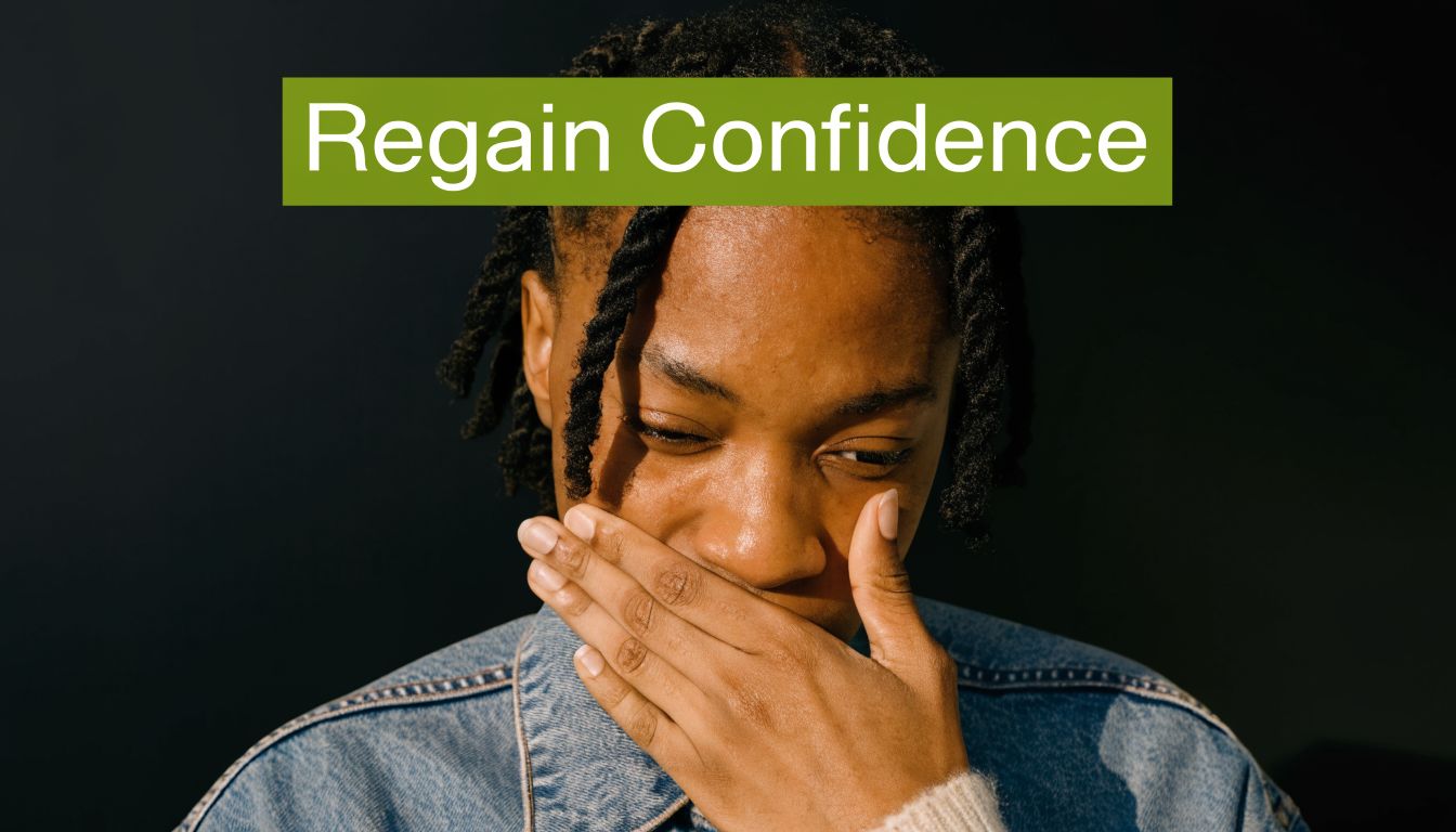 A person with braided hair looking down and covering their mouth with their hand in uncertainty.