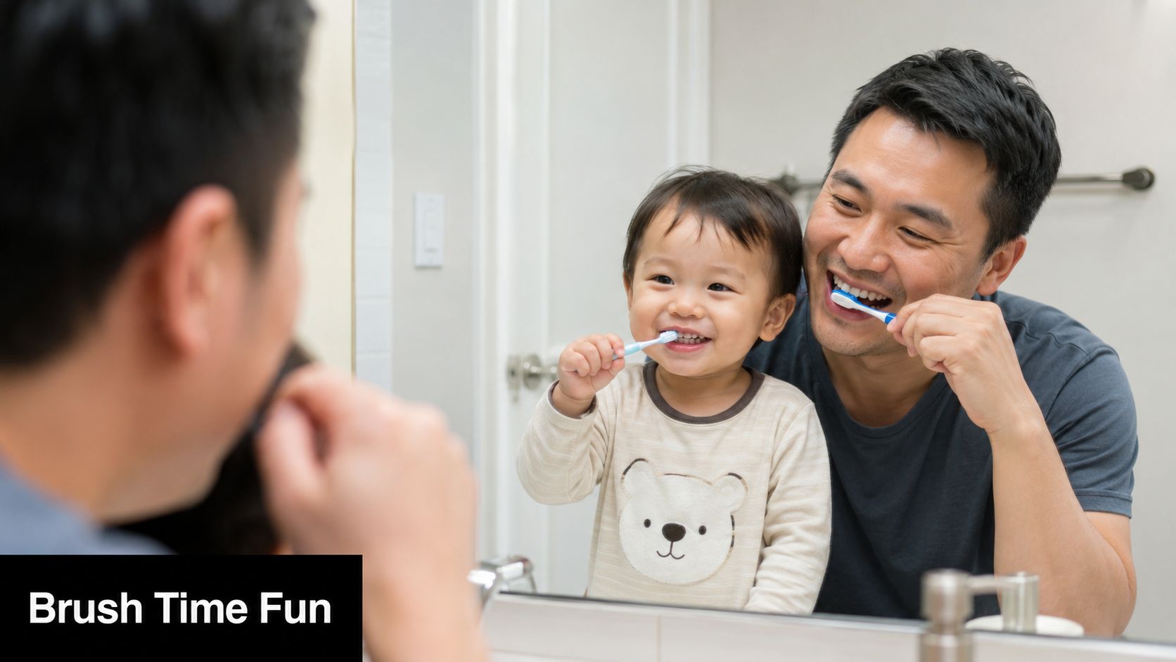 A happy toddler and father brushing their teeth together in front of a bathroom mirror.