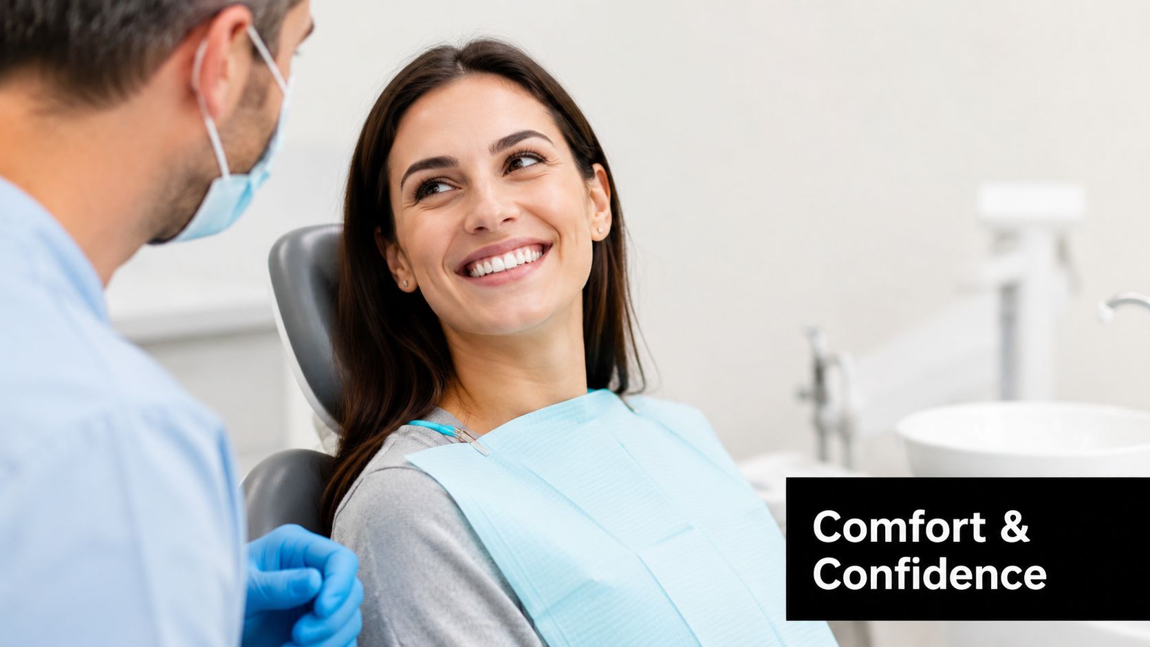 A dentist wearing a mask and gloves consults with a smiling female patient in an office.